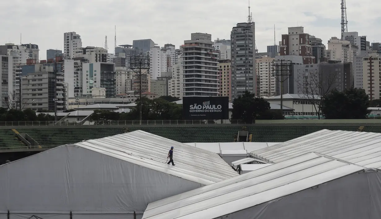 Seorang pria bekerja di lokasi pembangunan rumah sakit sementara di kompleks olahraga Ibirapuera di tengah merebaknya wabah COVID-19 di Sao Paulo (16/4/2020). Total pasien yang meninggal juga bertambah dari 1.736 menjadi 1.924, dengan tingkat kematian sebesar 6,3 persen. (Xinhua/Rahel Patrasso)