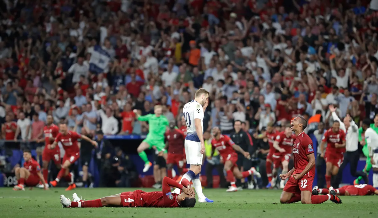 Pemain Tottenham Hotspur Harry Kane berjalan melewati pemain Liverpool yang sedang merayakan kemenangan di final Liga Champions di Stadion Wanda Metropolitano, Madrid, Spanyol, Sabtu (1/6/ 2019). (AP Photo/Felipe Dana)