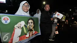 Seorang wanita membentangkan spanduk dengan gambar Sri Wahyuni peraih medali perak di Olimpiade Rio 2016, Jakarta, Selasa (23/8). Warga menyambut antusias kedatangan para atlet yang berlaga di Olimpiade Rio 2016. (Liputan6.com/Yoppy Renato)