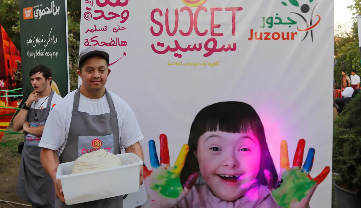 Seorang anak down syndrome Abdel Rahman bekerja di kedai kopi Sucet  selama festival "Sham gather us" di Damascus (11/7). Enam belas anak laki-laki dan perempuan down syndrome bekerja di Cafe Sucet melayani pelanggan. (AFP Photo/Louai Beshara)