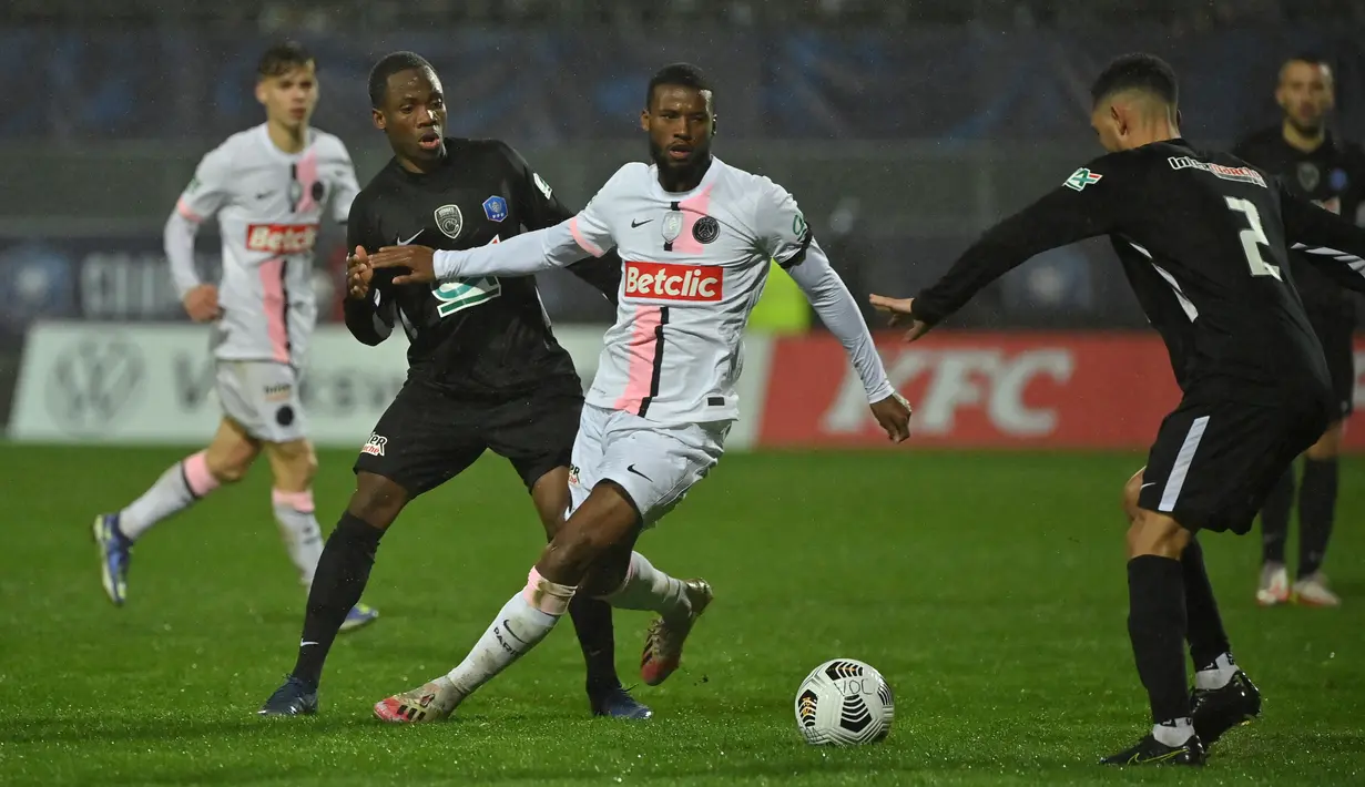 Gelandang Paris Saint-Germain (PSG) Georginio Wijnaldum (tengah) berebut bola dengan bek klub divisi empat, Vannes OC, Marcin Duclovel dalam babak 32 besar Piala Prancis di Stade de la Rabine, Selasa (4/1/2021) dini hari WIB. PSG menang 4-0 lewat hattrick Kylian Mbappe. (LOIC VENANCE/AFP)
