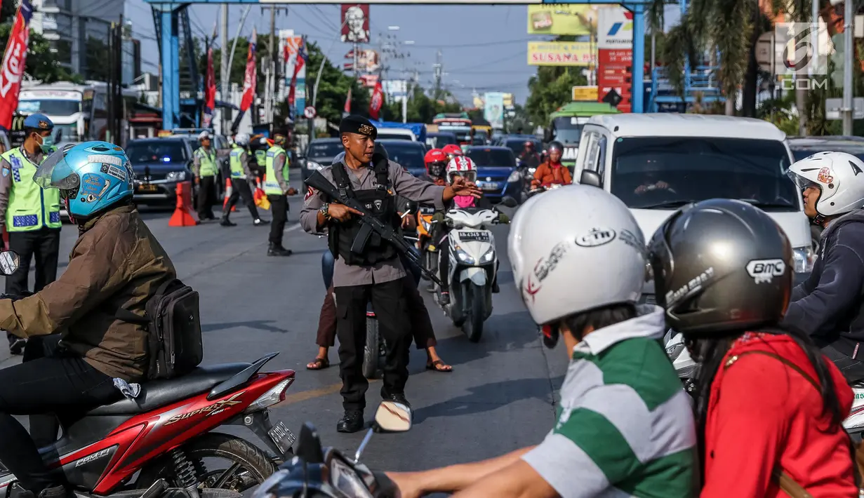 Personel Brimob bersenjata laras panjang ikut mengatur lalu lintas di kawasan jalur arus balik Pantura, Tegal, Jawa Tengah, Jumat (30/6). (Liputan6.com/Faizal Fanani)