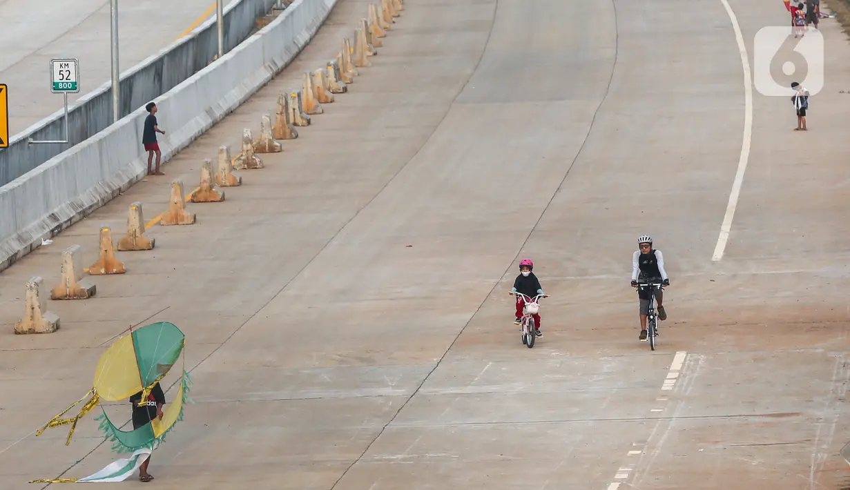 Warga bersepeda pada waktu sore di kawasan pembangunan Tol Serpong Kunciran, Ciputat, Tangerang Selatan, Kamis (25/6/2020). Selama PSBB Tangerang Raya, warga memanfaatkan waktu untuk berolahraga dan bermain layang-layang sambil hingga menjelang matahari terbenam. (Liputan6.com/Fery Pradolo)