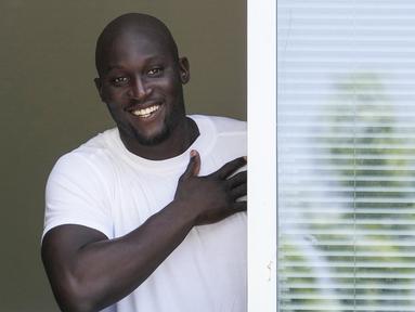 Penyerang asal Belgia, Romelu Lukaku tersenyum ke pendukung Inter Milan dari jendela markas Komite Olimpiade Italia di Milan, Italia, Rabu (29/6/2022). Lukaku sedang menjalani tes medis sebelum pindah kembali ke Inter dari Chelsea. (AP Photo/Luca Bruno)