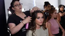 Seorang model saat ditata rambutnya di belakang panggung jelang tampil dalam Peragaan Busana Renang, Art Hearts Fashion Miami Swim Week di Collins Park, Miami, Florida, (14/7). (Arun Nevader/Getty Images Seni Hati Mode/AFP)