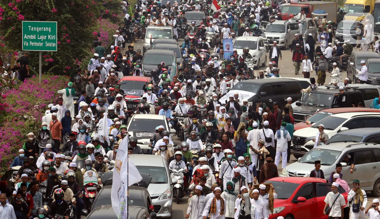 Ratusan massa berkonvoi mengawal Rizieq Shihab usai tiba di Bandara Soekarno-Hatta, Tangerang, Banten, Selasa (10/11/2020). Konvoi tersebut dilakukan untuk mengawal perjalan Rizieq Shihab menuju kediamannya di Petamburan, Jakarta. (Liputan6.com/Angga Yuniar)