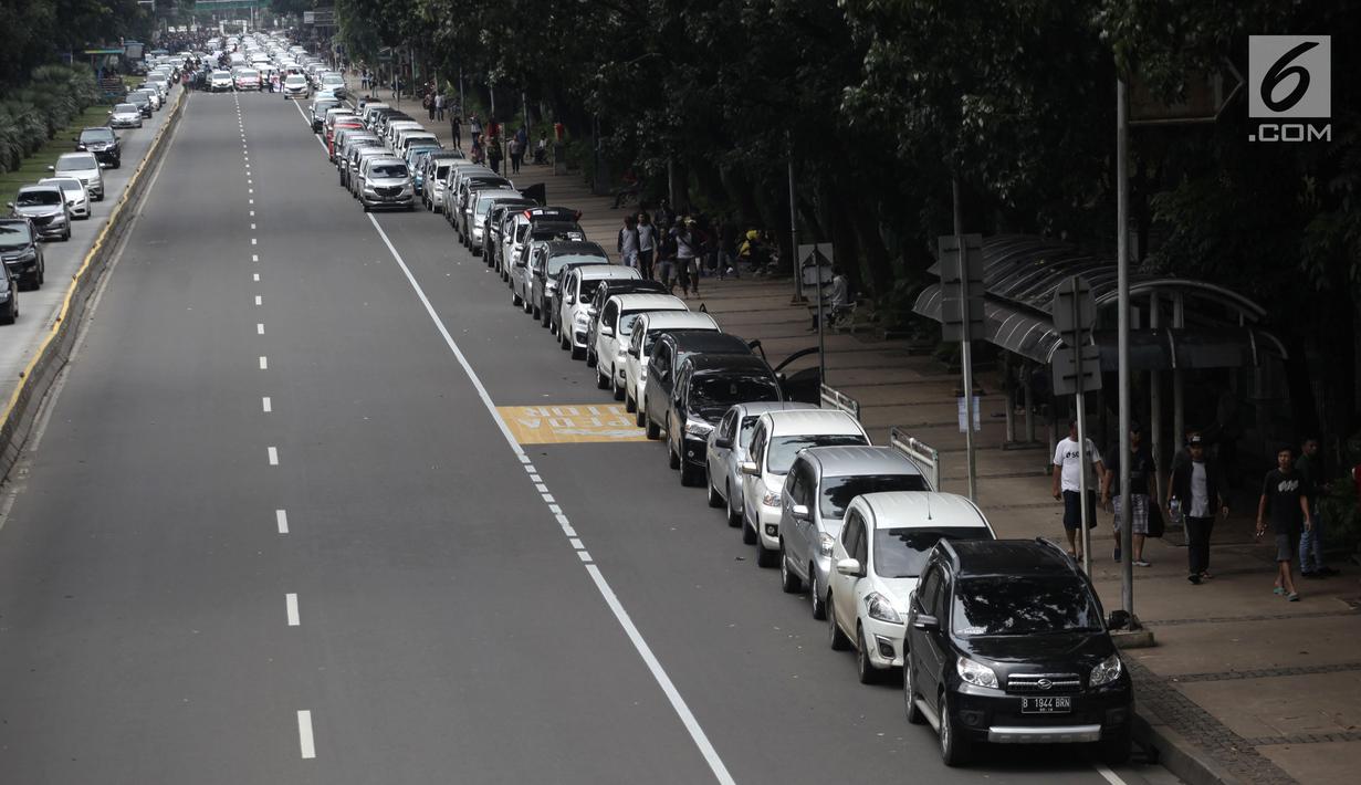 Ratusan mobil sopir taksi online terparkir di Jalan Medan Merdeka Barat, Jakarta, Rabu (14/2). Mereka menolak Permenhub Nomor 108 Tentang Penyelenggaraan Angkutan Orang Dengan Kendaraan Bermotor Umum Tidak Dalam Trayek. (Liputan6.com/Arya Manggala)