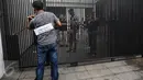 Salah satu adegan saat tersangka, yang perankan pemeran pengganti, mendatangi sebuah rumah lokasi perampokan dan pembunuhan dalam prarekonstruksi di perumahan Pulomas, Jakarta Timur, Jumat (6/1). (Liputan6.com/Faizal Fanani)