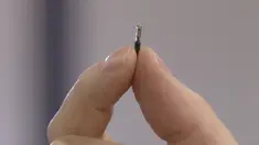 Direktur DSruptive Subdermals, Hannes Sjoblad memegang implan di antara jari-jarinya di Stockholm (20/12/2021). Perusahaan Swedia DSruptive Subdermals telah membuat microchip yang dapat dimasukkan di bawah kulit sehingga pengguna dapat membawa paspor Covid-19 di lengan mereka. (AFP/Viken Kantarci)