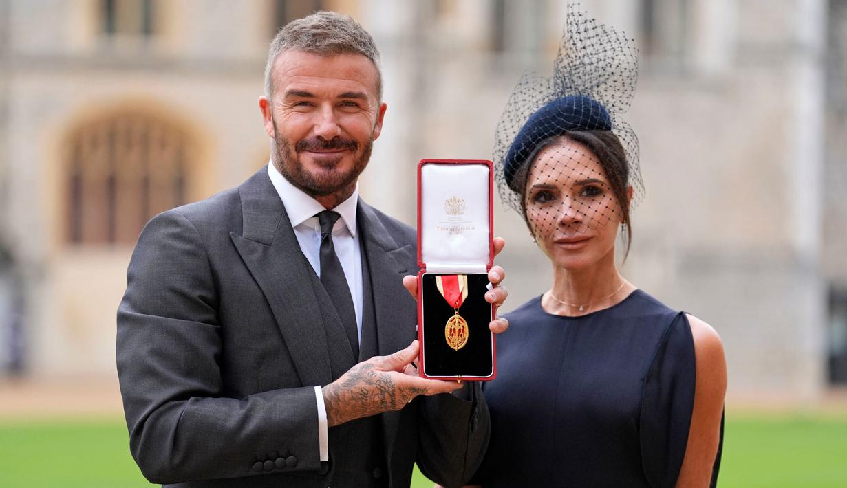 Mantan pesepak bola, Sir David Beckham (kiri) berfoto bersama dengan istrinya, Victoria Beckham sambil menunjukkan medali setelah dinobatkan gelar baru oleh raja Inggris, Charles III di Kastil Windsor, Berkshire, Inggris, Selasa (04/11/2025) waktu setempat. (AP Photo/Pool/Andrew Matthews)