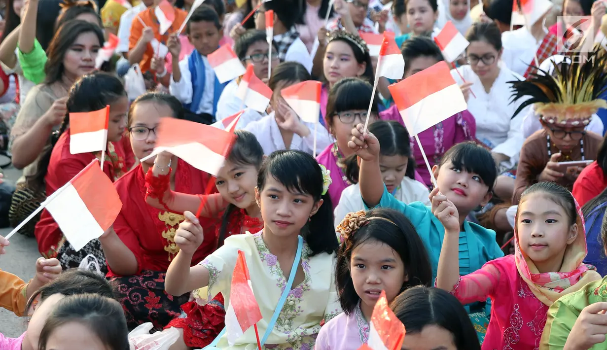 Sejumlah anak mengibarkan bendera Merah Putih saat gelaran Harmoni Indonesia 2018 di Kompleks Gelora Bung Karno, Jakarta, Minggu (5/8). Harmoni Indonesia adalah bernyanyi bersama secara serentak di 34 kota. (Liputan6.com/Helmi Fithriansyah)