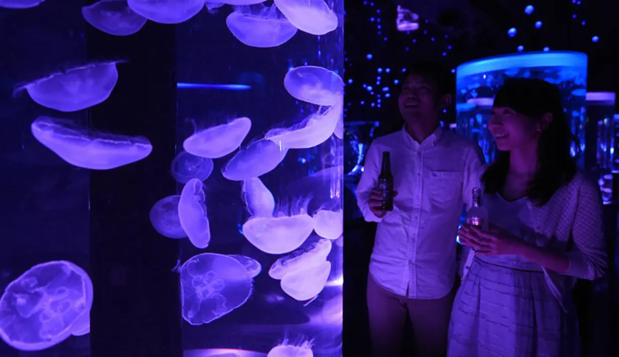 Pengunjung melihat Kawanan ubur-ubur di dalam akuarium Epson Aqua Park Shinagawa, Tokyo, Jepang (6/7/2015). Terdapat Ubur-ubur dengan berbagai bentuk saat pembukaan Epson Aqua Park Shinagawa. (AFP PHOTO/TOSHIFUMI KITAMURA)
