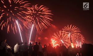 Pengunjung menyaksikan pesta kembang api saat malam Tahun Baru 2019 di Pantai Lagoon, Ancol, Jakarta, Selasa (1/1). Ancol menyajikan pesta kembang api musikal sepanjang 600 meter di bibir pantai dalam menyambut Tahun Baru 2019. (Merdeka.com/Iqbal Nugoho)