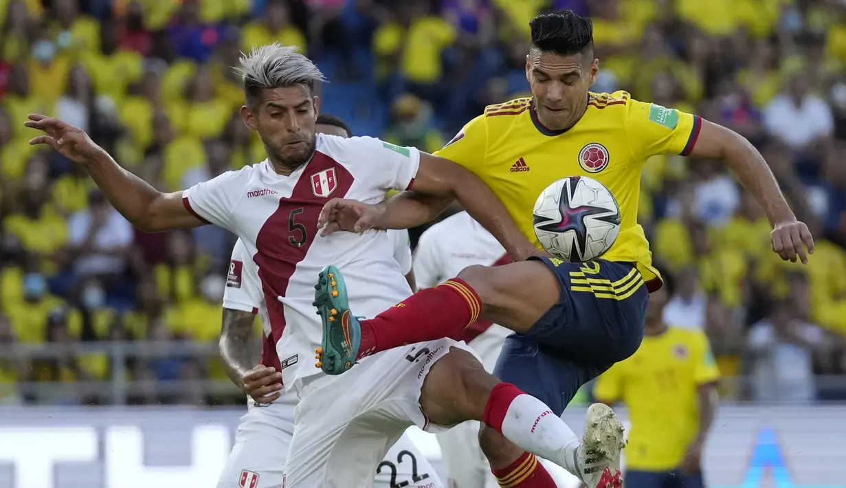 Penyerang Kolombia Radamel Falcao berebut bola dengan bek  Peru Carlos Zambrano pada lanjutan fase grup kualifikasi Piala Dunia 2022 zona Amerika Selatan, di Estadio Metropolitano Roberto Meléndez, Sabtu (29/1/2022) dini hari WIB. Peru menang 1-0. (AP Photo/Fernando Vergara)