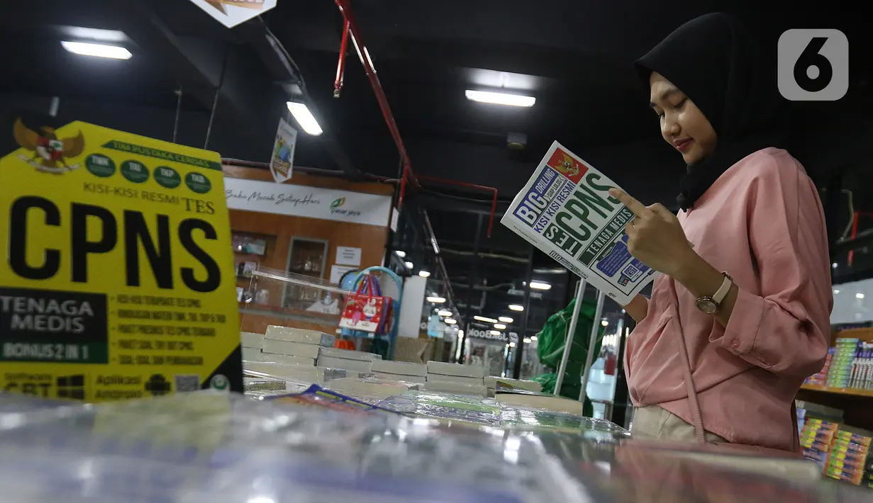 Pengunjung membaca buku panduan lolos tes CPNS di Pasar Kenari, Jakarta, Kamis (28/11/2019). Buku panduan lolos tes yang dijual mulai dari Rp 88.000 hingga Rp 195.000 per eksemplar menjadi barang yang paling dicari dan diminati jelang pelaksanaan tes CPNS. (Liputan6.com/Herman Zakharia)