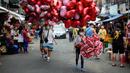 Penjual balon berbentuk hati menjajakan dagangannya di pasar bunga di Manila, Filipina, Senin (13/2/2023). Harga bunga naik karena tingginya permintaan sehari sebelum Hari Valentine. (AP Photo/Aaron Favila)
