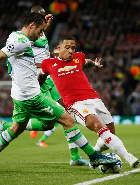 Penyerang MU, Memphis Depay (kiri) berusaha melewati gelandang Wolfsburg, Christian Trasch pada laga Liga Champions di Stadion Old Trafford, Inggris, Kamis (1/10/2015). MU menang atas Wolfsburg dengan skor 2-1. (Reuters/Andrew Yates)
