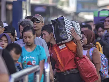 Sejumlah pemudik mengantre di pintu keberangkatan Stasiun Pasar Senen, Jakarta, Selasa (12/6). Sebanyak 25 ribu lebih pemudik berangkat dari Stasiun Pasar Senen dengan tujuan yang paling banyak dituju Semarang dan Surabaya. (Liputan6.com/Faizal Fanani)