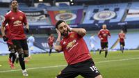 Gelandang Manchester United atau MU Bruno Fernandes berselebrasi usai mencetak gol ke gawang Manchester City dalam lanjutan Liga Inggris di Etihad Stadium, Minggu (7/3/2021).  (Laurence Griffiths/Pool via AP)