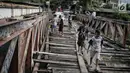 Anak anak bermain jembatan dari kayu yang menjadi penghubung antara Jalan Karet Pasar Baru VII, Karet Tengsin dan Jalan Pam Baru, Bendungan Hilir, Tanah Abang, Rabu (30/1). (Liputan6.com/Faizal Fanani)