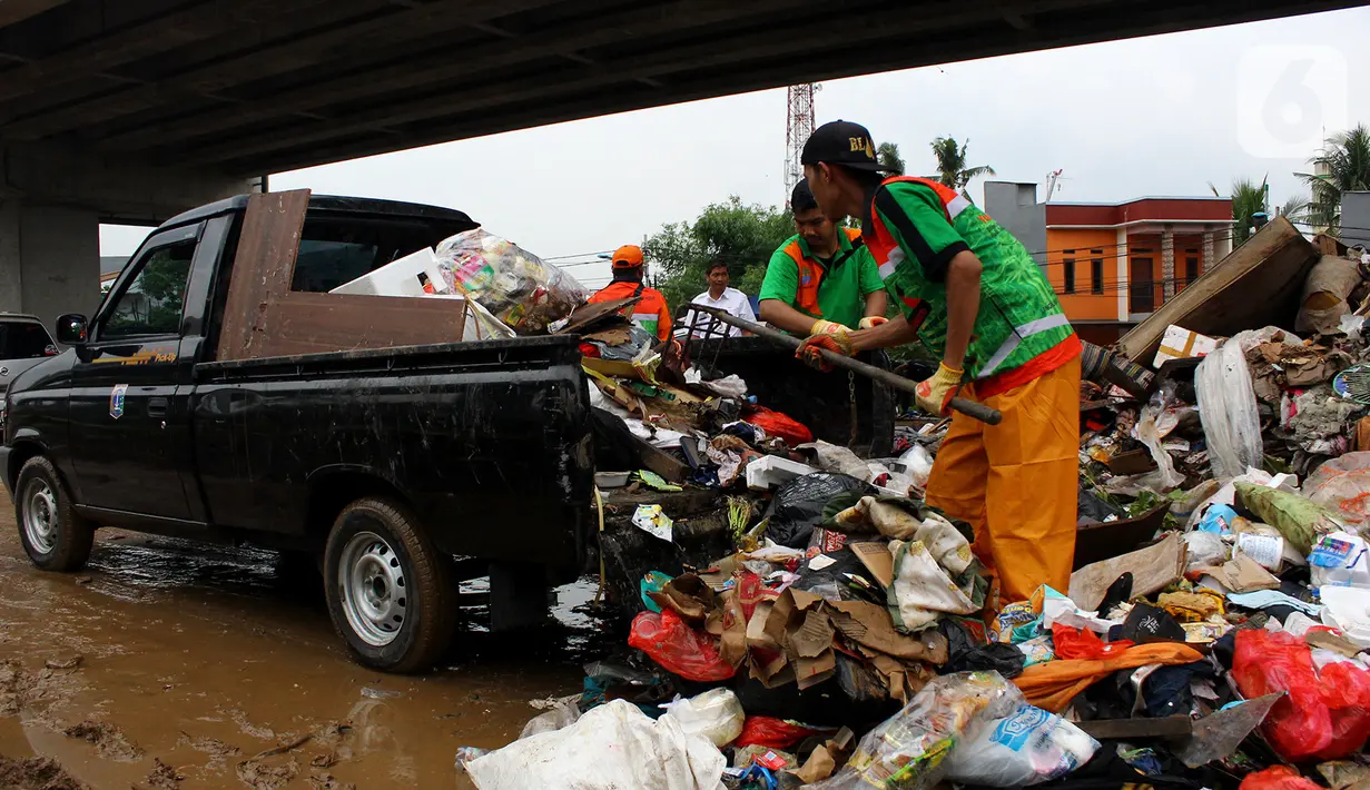 Petugas PPSU DKI Jakarta menaikkan sampah sisa banjir ke atas mobil di bawah Tol Becakayu, Cipinang Melayu, Jakarta Timur, Rabu (8/1/2020). Sampah sisa banjir tersebut selanjutnya diangkut ke TPA Bantar Gebang. (merdeka.com/Magang/Muhammad Fayyadh)