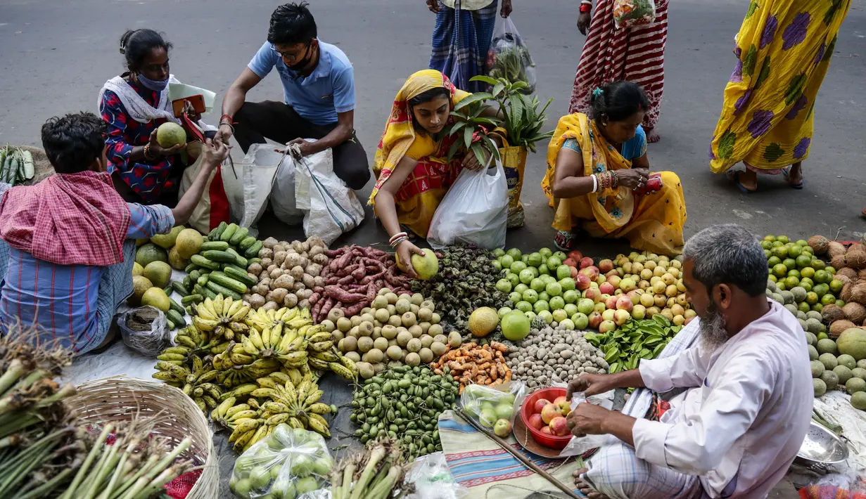 Pelanggan membeli buah-buahan di pinggir jalan menjelang festival Hindu Chhath, di Kolkata, India (9/11/2021). Selama Chhath, festival Hindu kuno yang populer di kalangan kelas pekerja, ritual dilakukan untuk berterima kasih kepada Dewa Matahari atas menopang kehidupan di bumi. (AP Photo/Bikas Das)