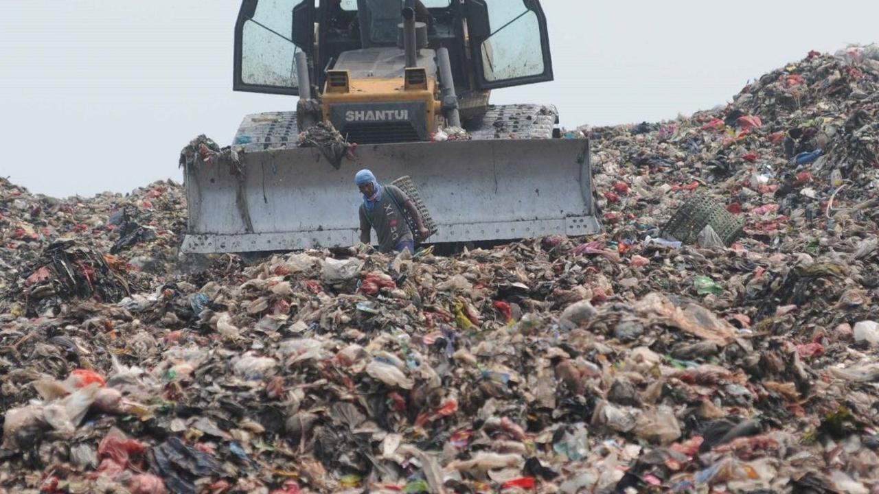 Alat berat eskavator  meratakan gunungan sampah di tempat Pembuangan Sampah Akhir (TPA) Burangkeng, Bekasi, Jawa Barat Senin (6/5/2024). TPA Burangkeng rencananya akan memperluas lahan pembuangan sampah. Foto: merdeka.com / Imam Buhori<br>
