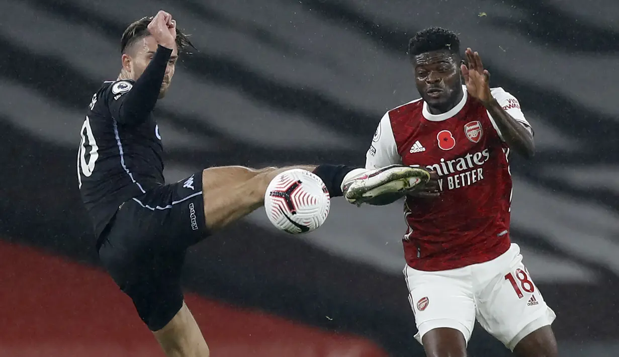 Gelandang Arsenal, Thomas Partey berbut bola dengan gelandang serang Aston Villa, Jack Grealish pada lanjutan Liga Inggris di Emirates Stadium, Senin (9/11/2020) dini hari WIB. Arsenal dibantai Aston Villa tiga gol tanpa balas. (AP Photo/Alastair Grant, Pool)
