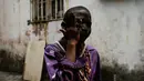 Seorang anak mengenakan pakaian yang menggambarkan "Cimarron" menggosok wajahnya dengan arang sebelum merayakan festival Congos and Devils di luar benteng San Jeronimo di Portobelo, Panama (18/3). (AP Photo / Arnulfo Franco)