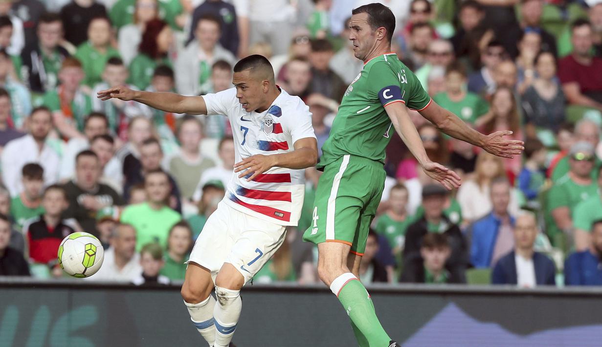 Pemain AS, Bobby Wood (kiri) mencoba melewati adangan pemain Irlandia, John O'Shea pada laga uji coba di Aviva Stadium, Dublin, (2/6/2018). Irlandia menang 2-1. (Brian Lawless/PA via AP)