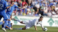 Striker Real Madrid, Cristiano Ronaldo, terjatuh saat pertandingan melawan Getafe pada laga La Liga Spanyol Stadion Coliseum Alfonso Perez, Sabtu (14/10/2017). Real Madrid menang 2-1 atas Getafe. (AP/Paul White)