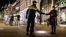 Polisi mengontrol sertifikasi keluar pada orang yang lewat saat jam malam dimulai di Haarlem, Belanda (23/1/2021). Belanda memasuki fase terberat dari pembatasan anti-virus Corona hingga saat ini. (AFP/ANP/Koen van Weel)