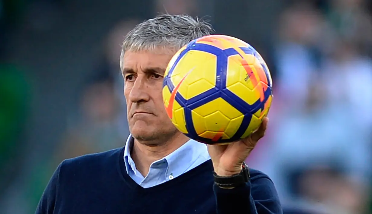 Pelatih Real Betis Quique Setien memegang bola saat anak asuhnya melawan Villarreal CF pada pertandingan Liga Spanyol di Stadion Benito Villamarin, Sevilla, 3 Februari 2018. Setien berpengalaman melatih Racing Santander, Poli Ejido, Logrones, Lugo, Las Palmas, dan Real Betis. (Cristina Quicler/AFP)