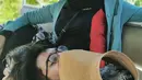 Momen saat Eril tertidur di pangkuan sang bunda di atas sebuah kendaraan. (Instagram/ataliapr)