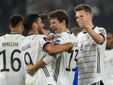 Penyerang timnas Jerman Thomas Muller diberi selamat oleh rekannya setelah mencetak gol kedelapan timnya ke gawang Liechtenstein dalam Kualifikasi Piala Dunia 2022 Zona Eropa di Volskwagen Arena, Jumat (12/11/2021) dinihari WIB. Jerman menang 9-0 atas tamunya Liechtenstein. (AP Photo/Michael Sohn)