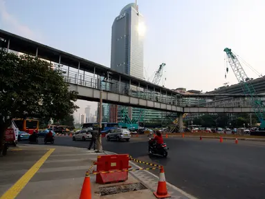 Suasana pembongkaran Jembatan Penyebrangan Orang (JPO) di Kawasan Bundaran HI, Jakarta, Senin (30/7). JPO yang sempat menimbulkan kontreversi itu dirobohkan karena alasan keindahan dan tak ramah penyandang disabilitas. (Liputan6.com/Johan Tallo)