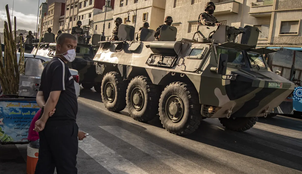 Tentara Maroko berpatroli di tengah wabah baru virus corona baru di kota Tangiers (11/8/2020). Tentara dikerahkan untuk meredam Lonjakan kasus Covid-19 di negara tersebut. (AFP/Fadel Senna)