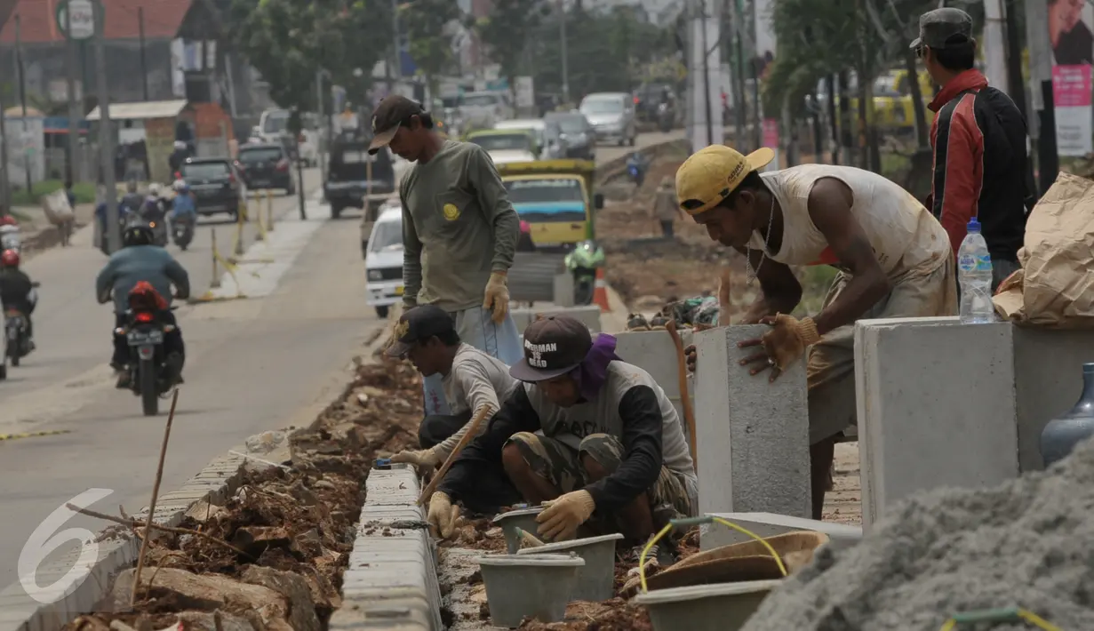 Pekerja saat menyelesaikan proyek rehabilitasi ruas jalan Ciputat-Pamulang, Tangerang Selatan, (28/1). Pemerintah Provinsi Banten akan melakukan rehab pada beberapa titik ruas jalan yang menghabiskan lebih dari Rp 21 miliar. (Liputan6.com/Faisal R Syam)