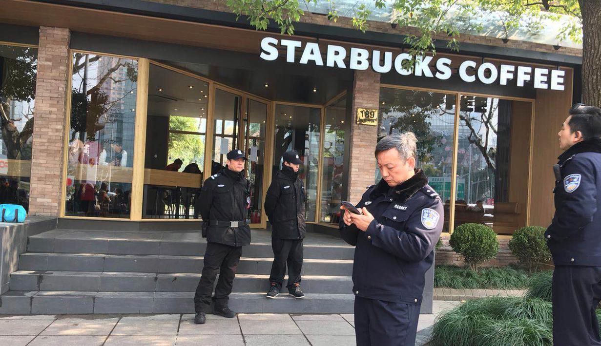 Petugas kepolisian berjaga di dekat lokasi  van yang menabrak pejalan kaki di trotoar daerah sibuk di Shanghai, Jumat (2/2). Sejumlah video dan foto yang beredar di media sosial memperlihatkan beberapa orang berbaring tak berdaya usai insiden. (AP Photo)