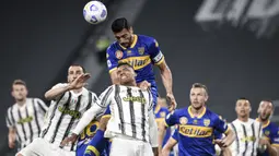 Pemain Juventus Alex Sandro (tengah) melompat untuk merebut bola dengan pemain Parma Graziano Pelle (atas) pada pertandingan Serie A di Stadion Allianz Turin, Italia, Rabu (21/4/2021). Juventus menang 3-1. (Piero Cruciatti/LaPresse via AP)