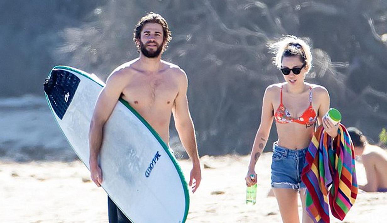 Pasangan yang selalu heboh dengan berita putus-nyambungnya ini dikabarkan tengah berbahagia. Miley Cyrus dan Liam Hemsworth terlihat sedang menikmati liburan mereka di sebuah pantai. (doc.dailymail.com)