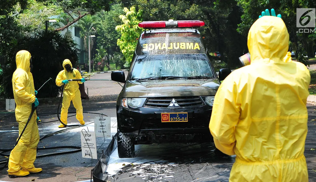 Tim Pasukan Gerak Cepat (PGC) yang terdiri dari Polisi dan TNI melakukan sterilisasi sebuah mobil yang kedapatan positif terjangkit pandemi influenza H7N9 saat simulasi penanganan di Puspiptek Tangerang Selatan, Rabu (20/9). (Liputan6.com/Helmi Afandi)