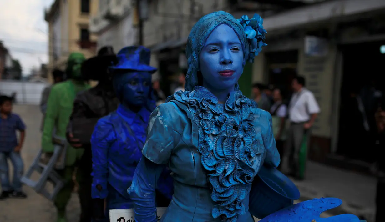 Kontestan berjalan saat  mengikuti kontes patung di pusat kota San Salvador , El Salvador, (18/6). Dengan mengecat seluruh tubuh mereka seperti patung, kita akan dibuat sulit membedakan mana patung asli dan tidak. (REUTERS / Jose Cabezas)