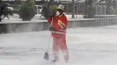 Petugas memakai masker membersihkan jalan yang tertutup abu setelah letusan awal gunung berapi Popocatepetl di Puebla, Meksiko, (18/4). Pemerintah Meksiko mengatakan gunung Popocatepetl menyemburkan abu vulkanis setinggi 3 km. (REUTERS/Imelda Medina)