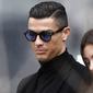 Cristiano Ronaldo bersama kekasihnya, Georgina Rodriguez, meninggalkan kantor pengadilan usai menghadiri sidang penggelapan pajak di Madrid, Spanyol (22/2/2019). (AFP/Oscar Del Pozo)