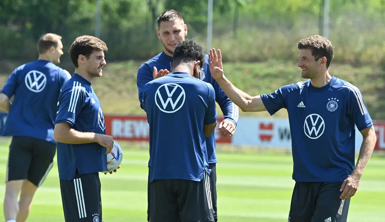 Pemain Jerman Thomas Mueller (kanan) bercanda dengan rekan setimnya saat sesi latihan di pusat olahraga BVSC, Budapest, Hungaria, 13 Juni 2022. Jerman akan menghadapi Italia pada pertandingan sepak bola UEFA Nations League. (Attila KISBENEDEK/AFP)