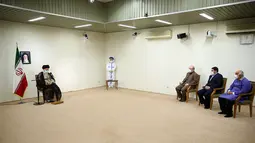 Pemimpin tertinggi Iran, Ayatollah Ali Khamenei berbincang dengan Menteri Kesehatan Iran Saeed Namaki (ketiga kanan) dan pejabat lainnya sebelum menerima dosis vaksin Covid-19 buatan lokal, COV-Iran Barekat, di Teheran, Jumat (25/6/2021). (KHAMENEI.IR / AFP)