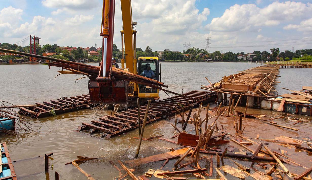 Sebelumnya, ditemukan bangunan berupa jembatan atau lintasan lari (jogging track) yang berdiri di atas badan air tanpa izin. Tampak dalam foto, petugas Dinas Sumber Daya Air Pemerintah Provinsi Jawa Barat membongkar tiang pancang beton yang dipasang di Setu Tujuh Muara, Sawangan, Depok, Senin (16/01/2026). (Merdeka.com/Arie Basuki)