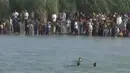 Sebuah gambar dari video yang dirilis Senin (6/6) menunjukkan warga Fallujah mencoba melarikan diri dengan menyebrangi Sungai Eufrat, untuk bisa keluar dari kota yang digempur pasukan pemerintah Irak, 3 Juni 2016. (REUTERS TV)