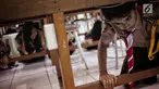 Sejumlah siswa berlindung di bawah meja saat simulasi bencana di SMA Negeri 78 Jakarta, Rabu (23/1). Kegiatan itu untuk pengenalan kepada siswa-siswi dengan program siaga bencana berupa simulasi evakuasi gempa dan tsunami. (Liputan6.com/Faizal Fanani)